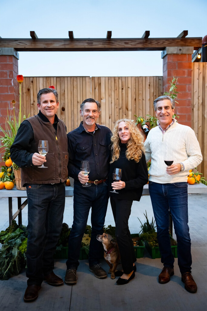 A group portrait of the Franzia family, including Carol, Michael, Paul, and Brian, all holding glasses Zinc House Wine, whilst smiling at the camera. 