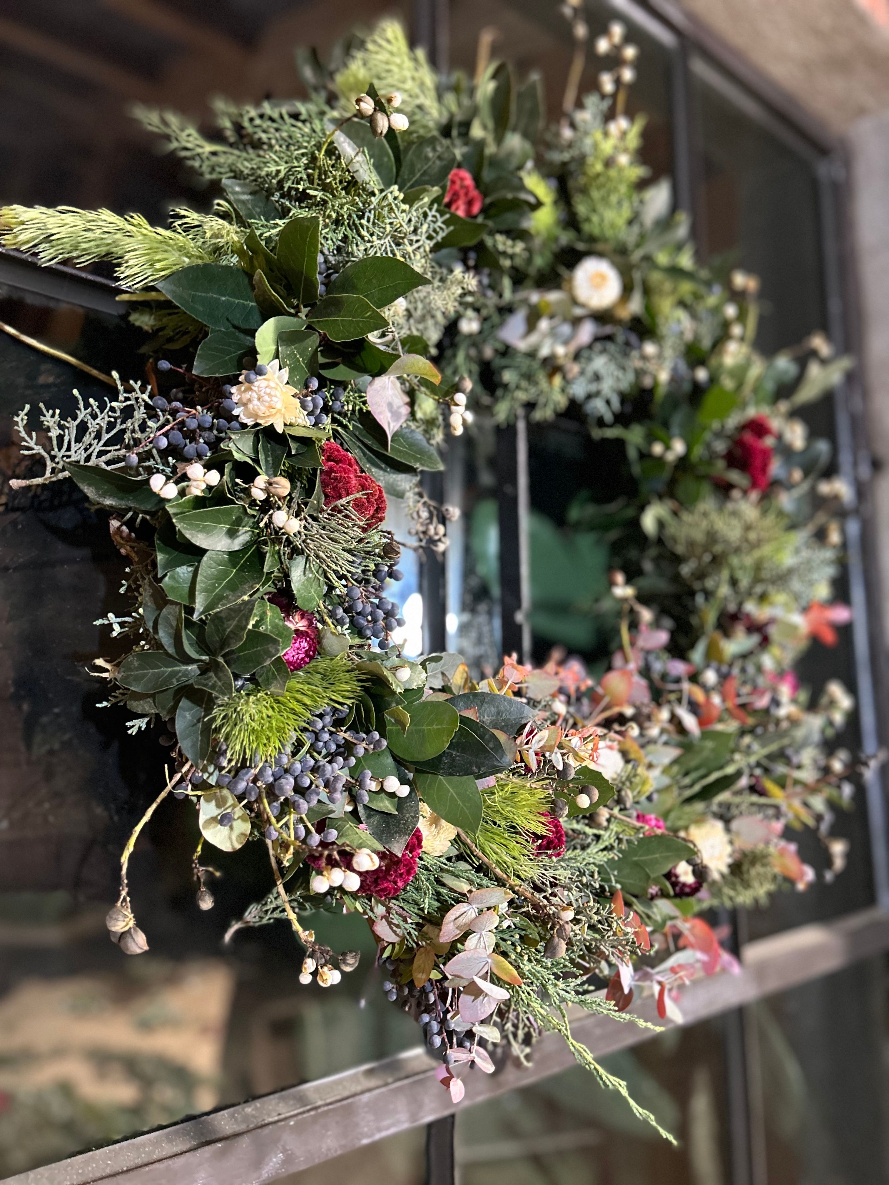 handmade holiday wreath with winter foliage and grapevines